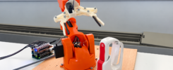 Arduino Braccio robot arm beside the Tactigon SKIN wearable gesture controller